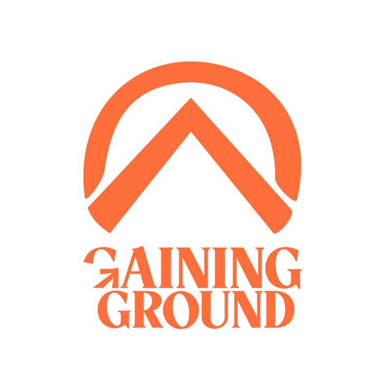 The Gaining Ground logo in orange on a black background. It features an abstract icon resembling a mountain above the name in a bold, serif font.